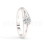 Anillo de compromiso estilo clúster, resalta un hermoso diamante forma brillante oval central y un ruedo de diamantes adicionales en forma de flor.