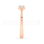 Anillo de compromiso estilo clúster, resalta un hermoso diamante forma brillante oval central y un ruedo de diamantes adicionales en forma de flor.