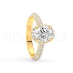 Anillo de compromiso estilo clúster, resalta un hermoso diamante forma brillante oval central y un ruedo de diamantes adicionales en forma de flor.